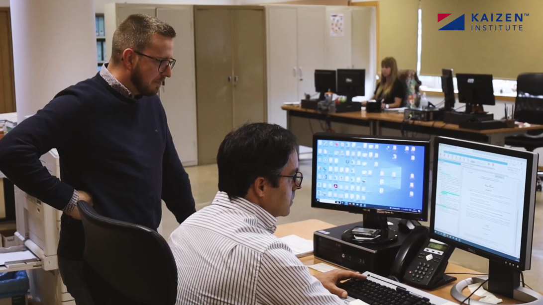 Dos personas en una oficina, mirando un ordenador