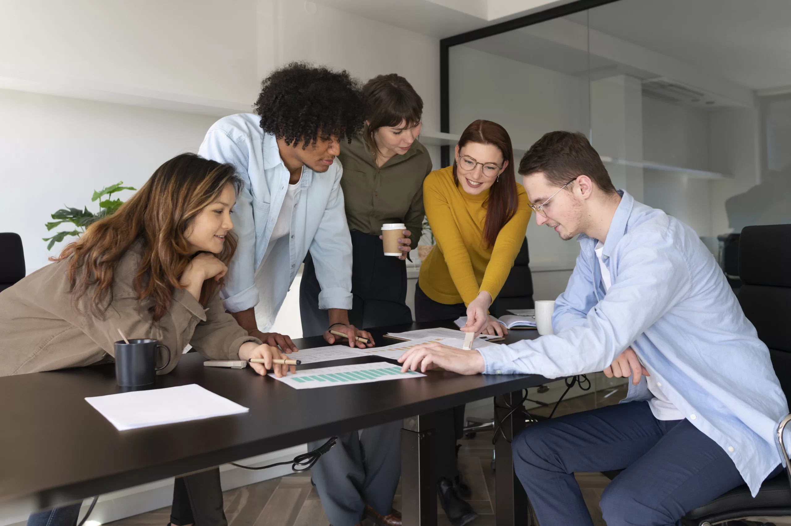 Coleagues meeting around a table talking Atrévete a ser excepcional: Carreras KAIZEN™